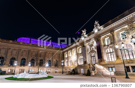 Grand Palais and Palais de la Decouverte in Paris France. Historic Beaux-Arts architecture features a grand staircase and illuminated purple glass roof in Square Jean Perrin Grand Palais and Palais de la Decouverte in Paris France. Historic Beaux-Arts architecture features a grand staircase and illuminated purple glass roof in Square Jean Perrin 136790807