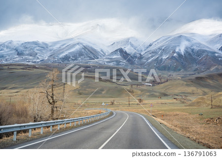 Mountain road and valley of Chuysky Trakt Altai Russia. Scenic route through rugged terrain and expansive natural landscape Mountain road and valley of Chuysky Trakt Altai Russia. Scenic route through rugged terrain and expansive natural landscape 136791063