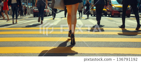 Women in high heels walking across a city street 136791192