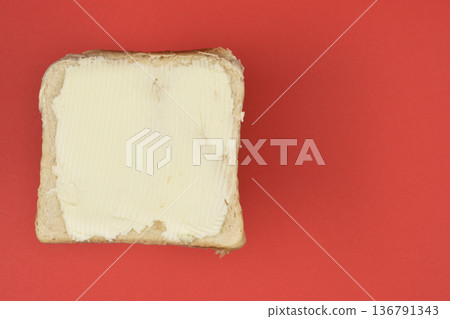 Butter Spread on Bread over Red Background 136791343