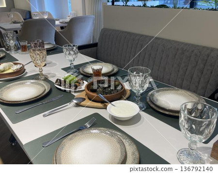 a table with macini's plate  and dolma's plate on the table 136792140