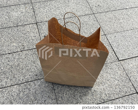 The paper bag on the sidewalk The paper bag on the sidewalk 136792150