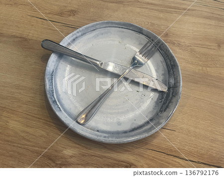 durty plate isolated on wooden table 136792176