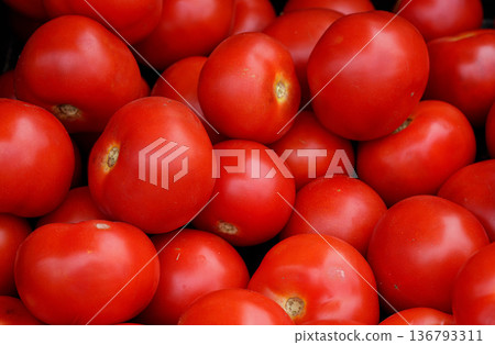 Heap of small bright red tomatoes, displayed on street food market, closeup detail from above Heap of small bright red tomatoes, displayed on street food market, closeup detail from above 136793311