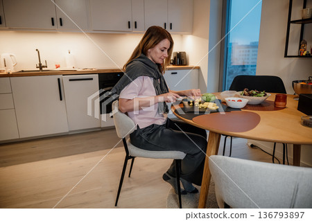 Cooking in a modern kitchen with fresh ingredients on a round table during evening hours 136793897