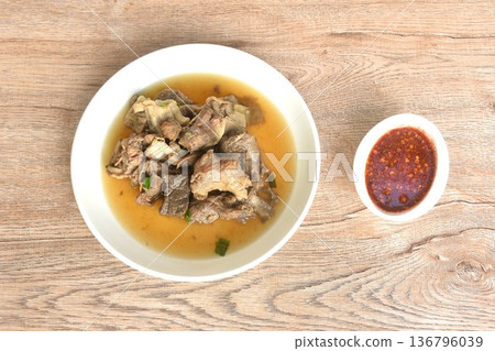 boiled braised beef meat and tendon in herb brown soup on plate dipping spicy chili sauce  136796039