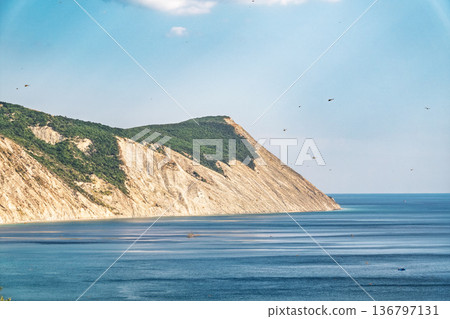 High mountain slopes to the Black Sea coast in Anapa, Russia. Coastline in sunset, beautiful sea scenery. Anapa coast landscape, high cliff High mountain slopes to the Black Sea coast in Anapa, Russia. Coastline in sunset, beautiful sea scenery. Anapa coast landscape, high cliff 136797131