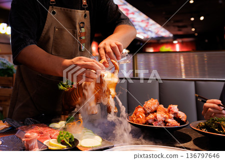 Chef skillfully prepares seafood dish with dry ice effects at a vibrant restaurant during evening hours Chef skillfully prepares seafood dish with dry ice effects at a vibrant restaurant during evening hours 136797646