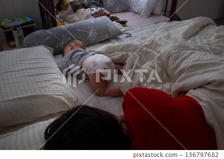 Mother and child sleeping together in cozy bedroom Mother and child sleeping together in cozy bedroom 136797682