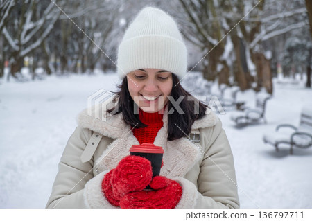 Woman Enjoying Hot Drink in Snowy Park Woman Enjoying Hot Drink in Snowy Park 136797711