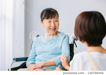 Senior women with caregivers and wheelchairs Senior women with caregivers and wheelchairs 136798448