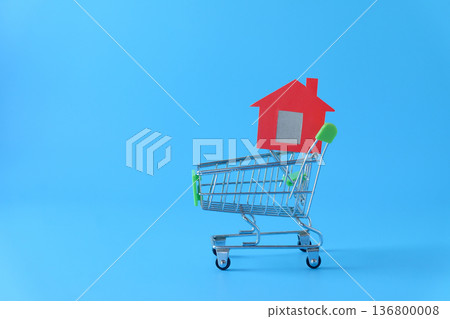 Mini red house in shopping cart on background. Mini red house in shopping cart on background. 136800008