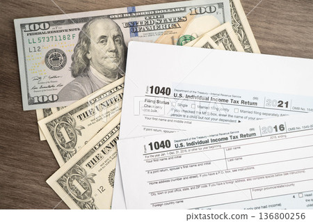 Tax form 1040 U.S. Individual Income Tax Return with dollar banknotes money. Tax form 1040 U.S. Individual Income Tax Return with dollar banknotes money. 136800256