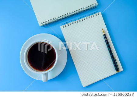 Black coffee with blank booknote on blue background. 136800287