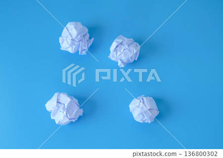 A crumpled sheet of paper on blue background. 136800302