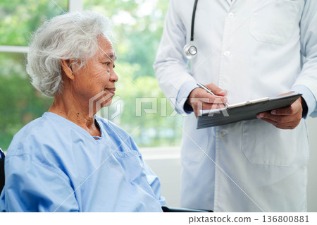 Doctor taking care, help and encourage Asian elder senior woman patient in clinic hospital. 136800881