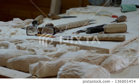 Carving studio showing woodworking tools, Artisan workspace filled with carving instruments and wood pieces, Interior of woodworking studio featuring tools and crafted wood designs Carving studio showing woodworking tools, Artisan workspace filled with carving instruments and wood pieces, Interior of woodworking studio featuring tools and crafted wood designs 136801454