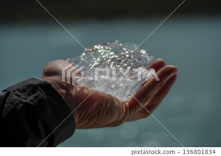 Hand holding piece of ice fallen from the spegazzini glacier los glaciares park argentina 136801834
