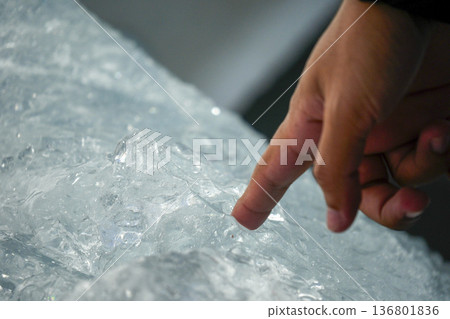 Finger of human hand touching piece of ice fallen from the spegazzini glacier los glaciares park argentina Finger of human hand touching piece of ice fallen from the spegazzini glacier los glaciares park argentina 136801836