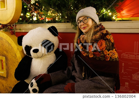 Enjoying a cozy evening with a giant panda in a festive winter setting 136802004