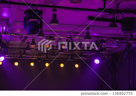 Dramatic purple stage lighting illuminates overhead rigging and spotlights Dramatic purple stage lighting illuminates overhead rigging and spotlights 136802755