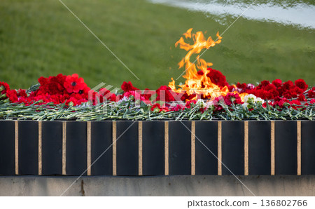 Mass grave outdoor memorial with flowers and fire Mass grave outdoor memorial with flowers and fire 136802766