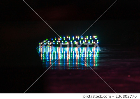 A horizontal row of colorful LED lights creates a bokeh strip and vivid reflection 136802770