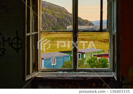 Weathered wooden houses in Teriberka at dusk, Russia, Kola Peninsula, evoke a bygone era, standing as silent witnesses to the passage of time. Teriberka's historical architecture concept Weathered wooden houses in Teriberka at dusk, Russia, Kola Peninsula, evoke a bygone era, standing as silent witnesses to the passage of time. Teriberka's historical architecture concept 136803335