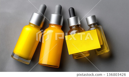 Skincare serum bottles with dropper caps arranged on textured surface showcasing amber glass cosmetic packaging minimal branding and product mockup 136803426