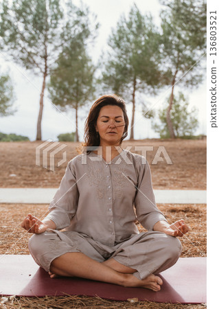 Meditative Woman Practicing Yoga Outdoors in Nature Meditative Woman Practicing Yoga Outdoors in Nature 136803521