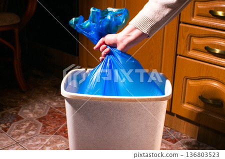 Woman taking garbage bag out of trash bin, closeup Woman taking garbage bag out of trash bin, closeup 136803523