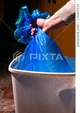 Woman taking garbage bag out of trash bin, closeup Woman taking garbage bag out of trash bin, closeup 136803524