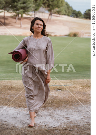 Woman with Yoga Mat Preparing for Outdoor Practice Woman with Yoga Mat Preparing for Outdoor Practice 136803535