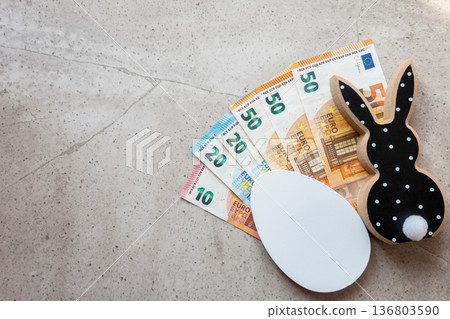 Black and white wood rabbit and egg with cash euro money for easter celebration on the stone background. Shopping of Easter holidays. Space for text. 136803590