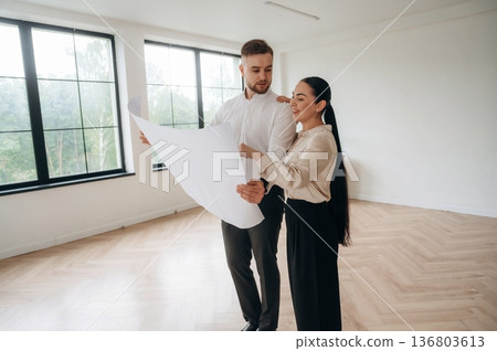 Reading the plan of room. Man and woman are indoors, conception of business 136803613