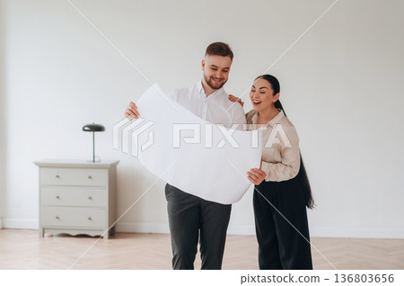 Reading the plan of room. Man and woman are indoors, conception of business 136803656