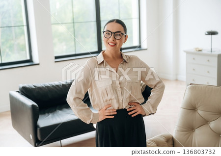 Smiling, positive facial expression. Woman in formal clothes is in the modern big room 136803732