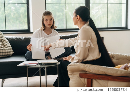 Papers with copy space. Girl at a psychologist's appointment Papers with copy space. Girl at a psychologist's appointment 136803784