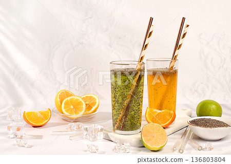 Modern still life with citrus fruits. Diet vegan cocktail with chia seeds, orange, lime, violet and ice. Detox diet and weight loss concept. Summer banner and screen template. 136803804