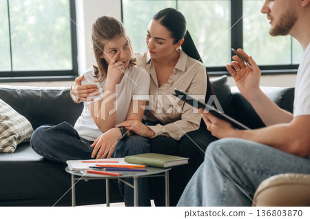 Embracing the sad girl. Mother with her daughter are at psychologist appointment 136803870
