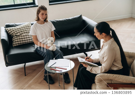 Holding toy bear. Girl at a psychologist's appointment Holding toy bear. Girl at a psychologist's appointment 136803895