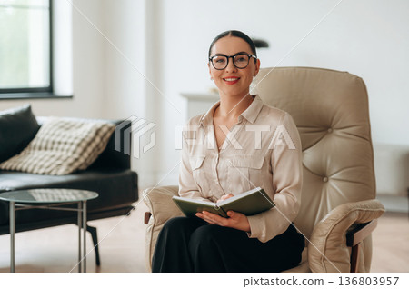 Smiling, positive facial expression. Woman in formal clothes is in the modern big room 136803957
