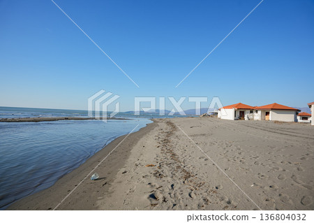Sandy Beach with Beach Huts and Calm Sea Sandy Beach with Beach Huts and Calm Sea 136804032