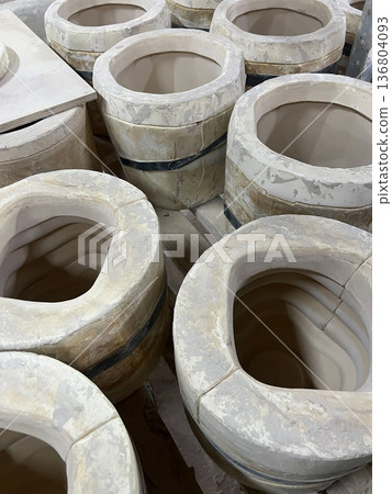 Clay vessels are arranged and prepared for pottery making in a vibrant ceramic workshop, showcasing artistic techniques and craftsmanship 136804093