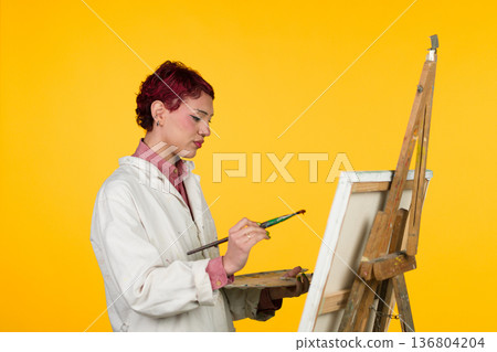 Young artist painting on canvas creating new artwork 136804204