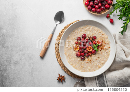 Oatmeal with cranberry, cinnamon and spicy in a plate on a gray concrete background 136804250