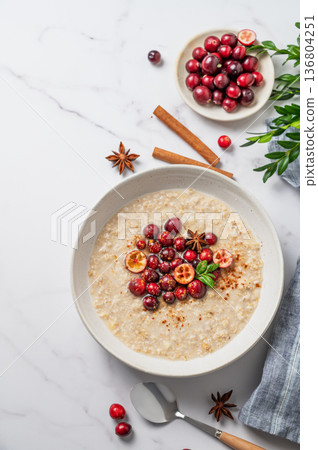 Oatmeal with cranberry, cinnamon and spicy in a plate on a marble background 136804251