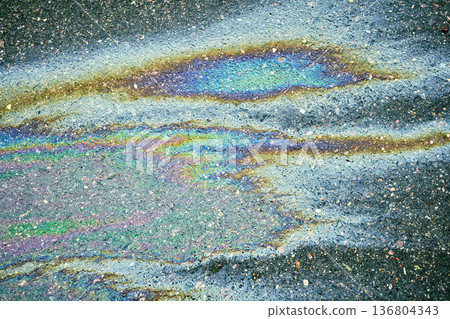 Oil spill on wet asphalt surface creating colorful iridescent rainbow patterns. Concept of environmental pollution and abstract background Oil spill on wet asphalt surface creating colorful iridescent rainbow patterns. Concept of environmental pollution and abstract background 136804343
