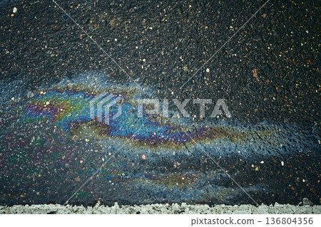 Colorful oil slick forming mesmerizing designs on the wet asphalt after rain Colorful oil slick forming mesmerizing designs on the wet asphalt after rain 136804356