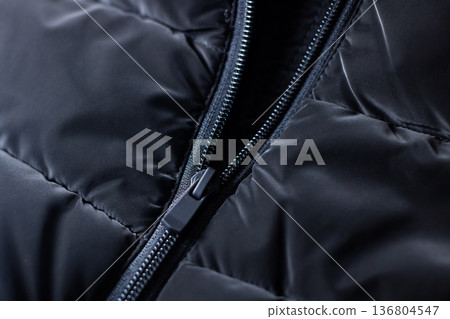 Macro perspective focusing on zipper and stitching design of insulated streetwear coat 136804547